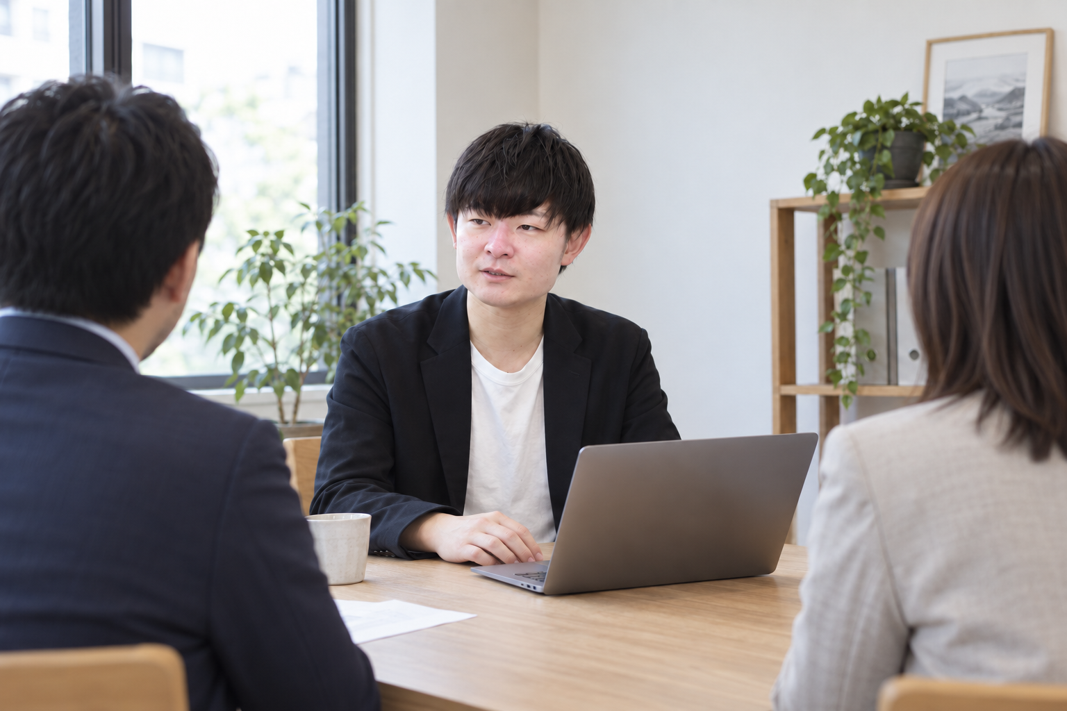 企業の担当者と業務の進め方を話し合う本保雄太のイメージ