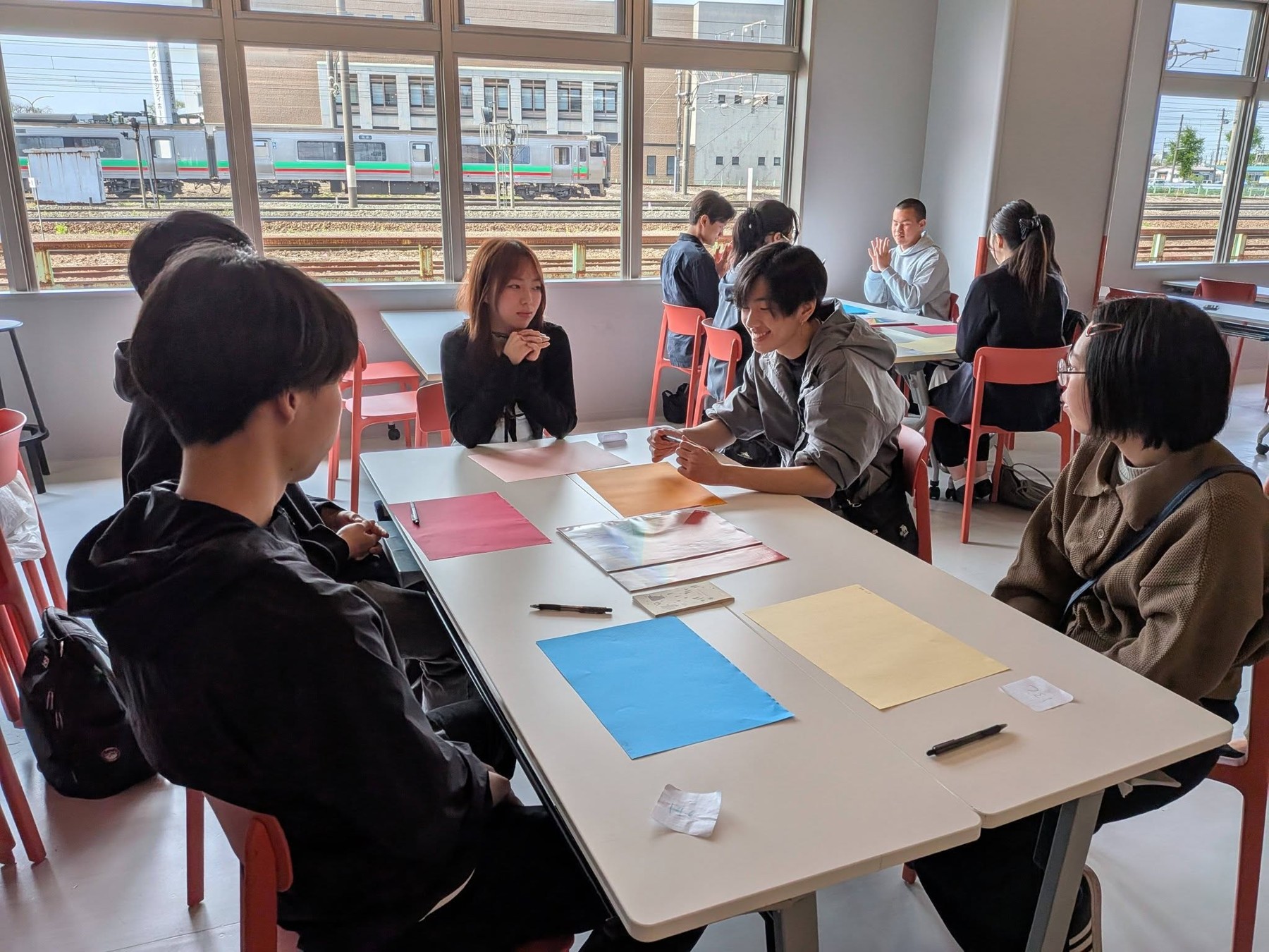 説明会の参加者がテーブルを囲んで話し合う様子